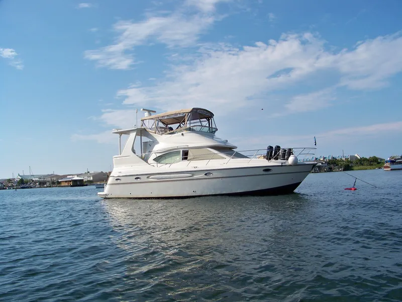 The Image of 1999 Maxum 4100 SCA yacht on calm water under clear sky. - 0