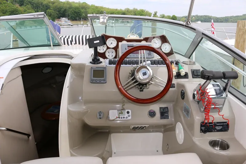 Slide: The Image of 2009 Larson Cabrio 310 boat cockpit with steering wheel and control panel. - 10