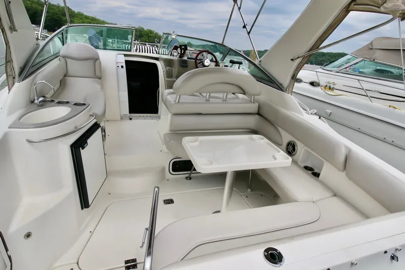 Slide: The Image of 2009 Larson Cabrio 310 boat interior with seating, table, and kitchenette. - 11
