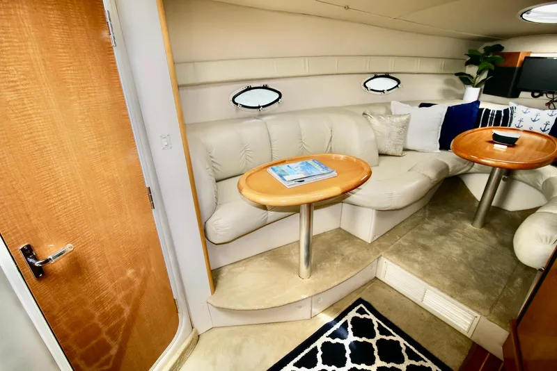 Slide: The Image of Interior of 2009 Larson Cabrio 310 yacht with plush seating and wooden tables. - 22