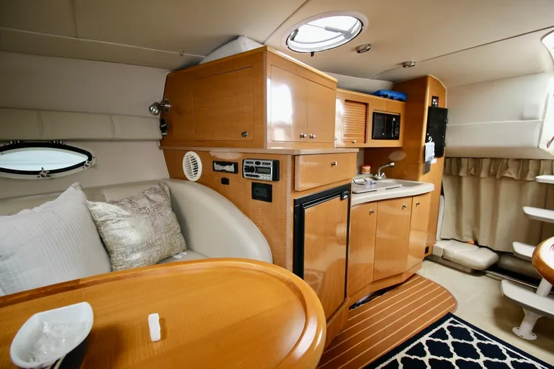 Slide: The Image of 2009 Larson Cabrio 310 cabin interior with kitchenette, seating, and modern amenities. - 23