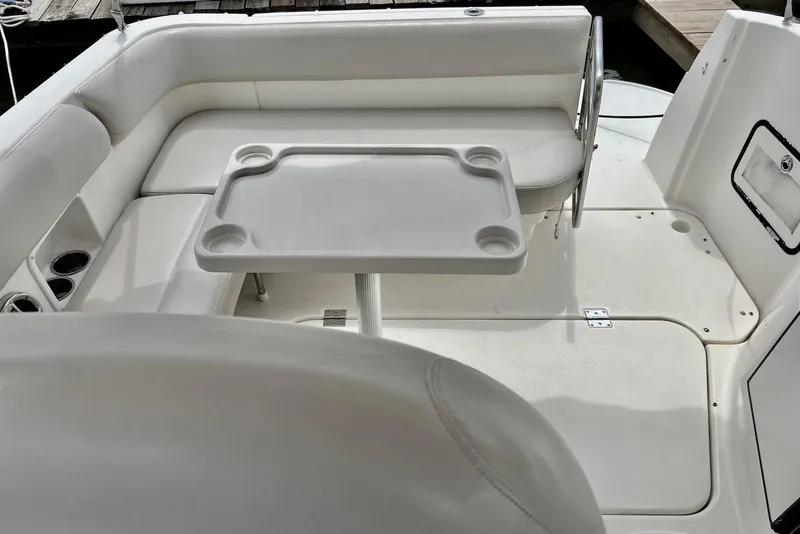 Slide: The Image of 2009 Larson Cabrio 310 boat interior with white seating and table. - 27
