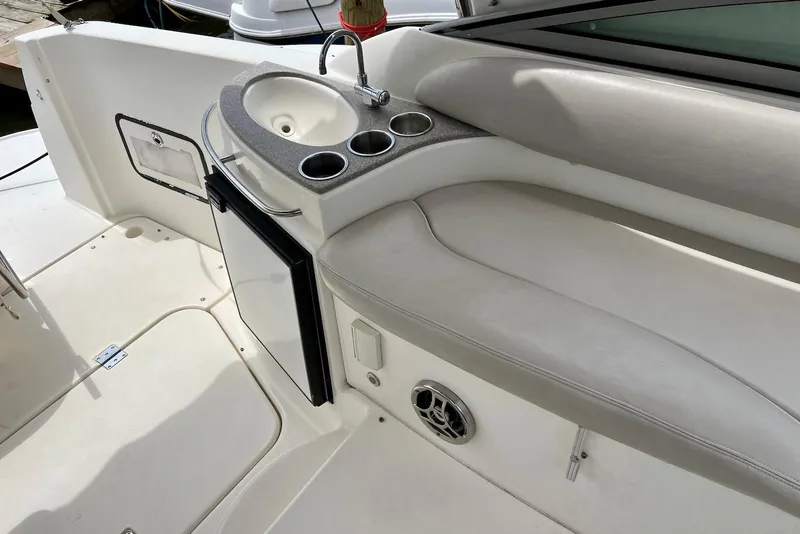 Slide: The Image of 2009 Larson Cabrio 310 boat interior with sink, cup holders, and seating area. - 28