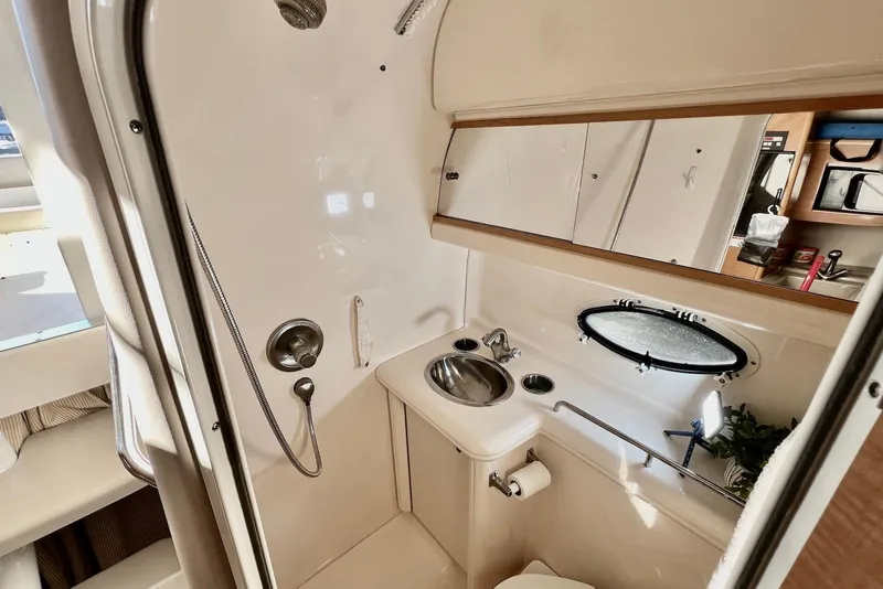 Slide: The Image of 2009 Larson Cabrio 310 boat bathroom with shower, sink, and mirror. - 34