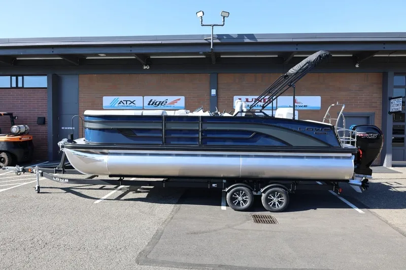 The Image of 2026 Lowe SS 230 CL pontoon boat on trailer outside dealership. - 1