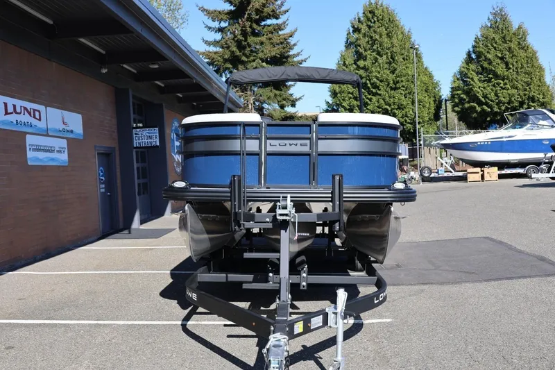 Slide: The Image of 2026 Lowe SS 230 CL pontoon boat on trailer outside dealership. - 12