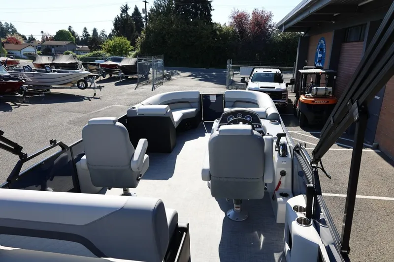Slide: The Image of 2026 Lowe SS 230 CL pontoon boat interior with seating and steering console. - 18
