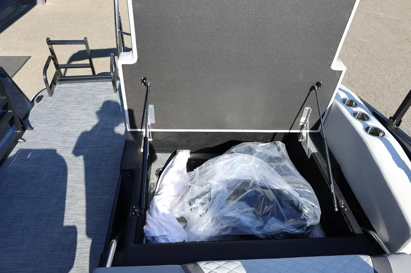 Slide: The Image of 2026 Lowe SS 230 CL boat storage compartment with open lid and packaged items inside. - 21