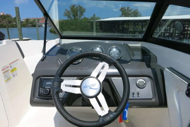 Slide: The Image of 2017 Sea Ray SPX 190 Outboard dashboard with steering wheel and gauges, dockside view. - 16