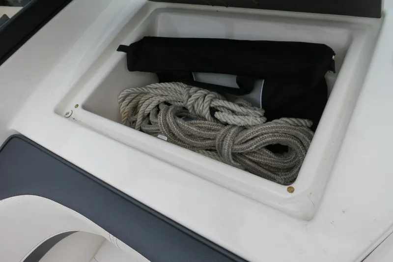 Slide: The Image of Storage compartment on 2017 Sea Ray SPX 190 Outboard with coiled rope and black bag. - 25