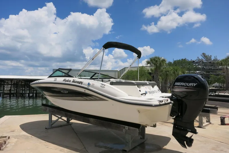 Slide: The Image of 2017 Sea Ray SPX 190 Outboard boat on dock, featuring Mercury engine, under blue sky. - 5