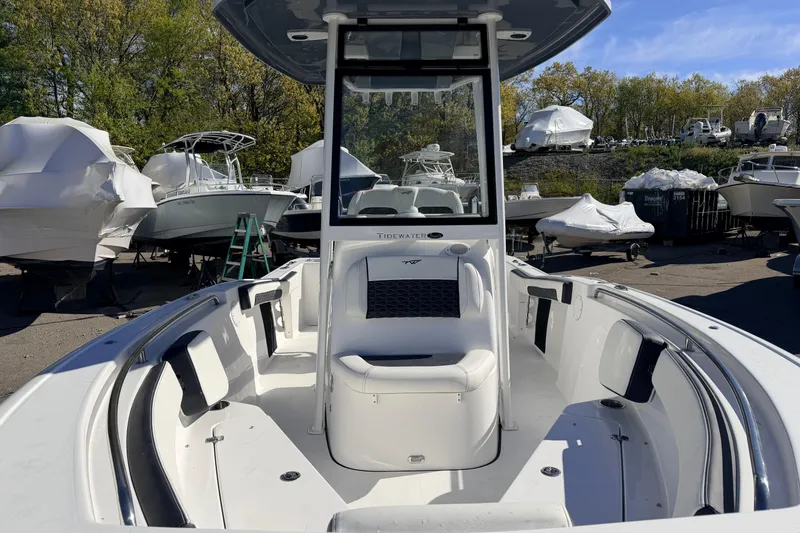 Slide: The Image of 2026 Tidewater 210 CC Adventure boat with seating, docked among other boats. - 11