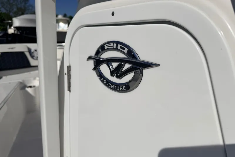Slide: The Image of 2026 Tidewater 210 CC Adventure boat emblem on white surface. - 22