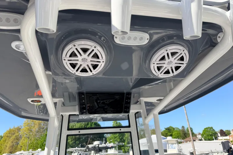 Slide: The Image of 2026 Tidewater 210 CC Adventure boat speakers and rod holders on T-top. - 9