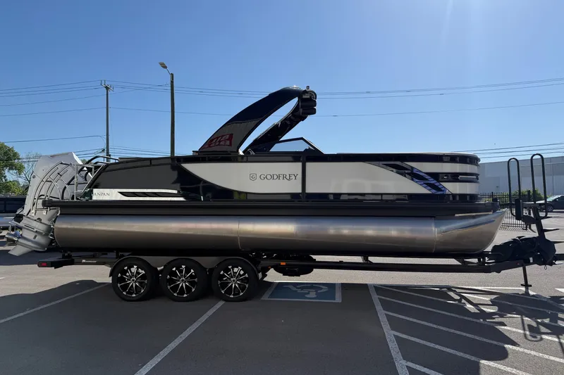 The Image of 2024 Godfrey Sanpan 2500 DFLW pontoon boat on trailer in parking lot. - 0