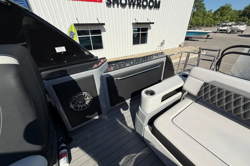 Slide: The Image of Interior of 2024 Godfrey Sanpan 2500 DFLW boat at showroom, featuring seating and speaker. - 13
