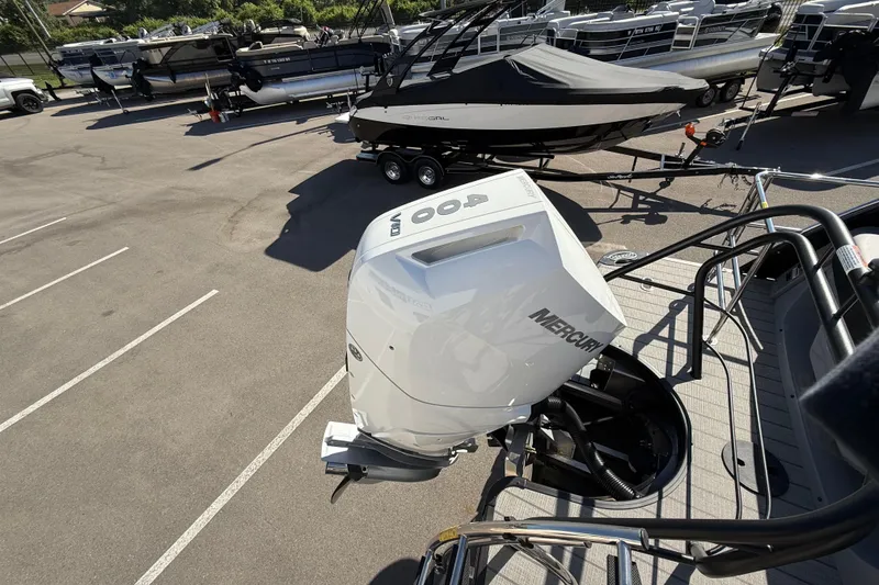 Slide: The Image of 2024 Godfrey Sanpan 2500 DFLW with Mercury outboard engine in a parking lot. - 18