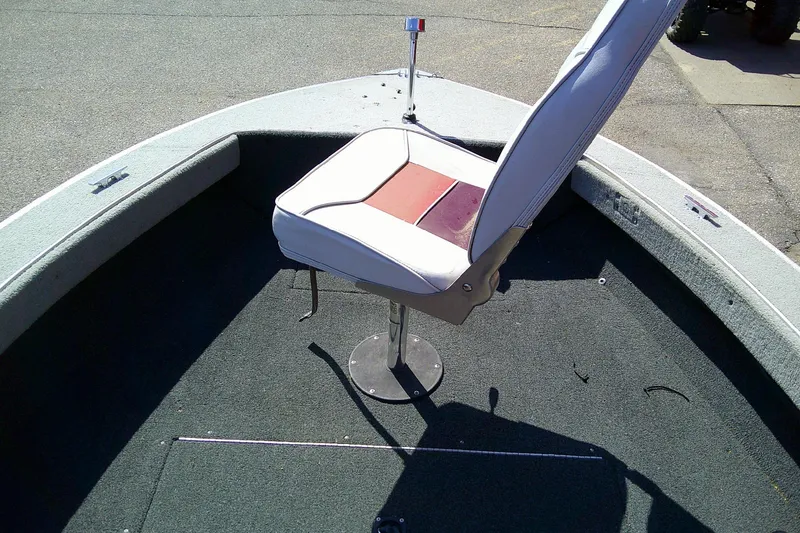Slide: The Image of 1989 Bass Tracker Pro Deep V-17 boat interior with swivel seat on carpeted deck. - 10