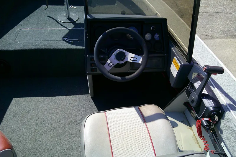 Slide: The Image of 1989 Bass Tracker Pro Deep V-17 boat cockpit with steering wheel and controls. - 9