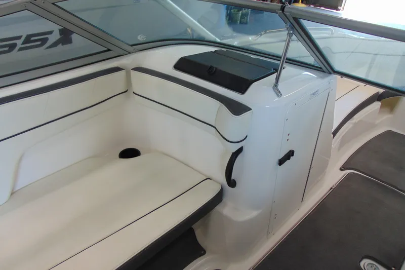 Slide: The Image of Interior of a 2014 Yamaha Boats AR210, featuring white seating and storage compartment. - 10