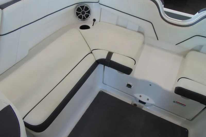 Slide: The Image of 2014 Yamaha AR210 boat interior seating with white upholstery and speaker. - 14