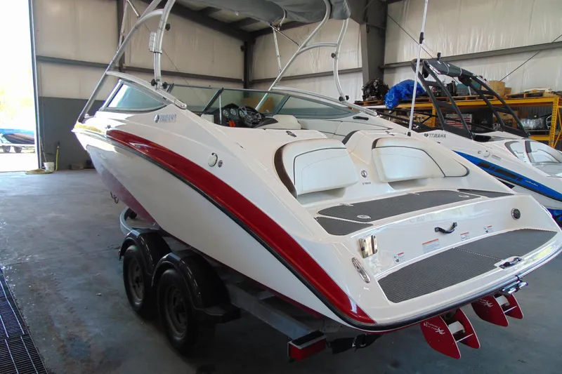 Slide: The Image of 2014 Yamaha Boats AR210 in a garage, showcasing sleek design and dual engines. - 4