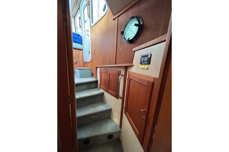 Slide: The Image of Interior view of 2003 American Tug 34, featuring wooden cabinetry and carpeted stairs. - 11