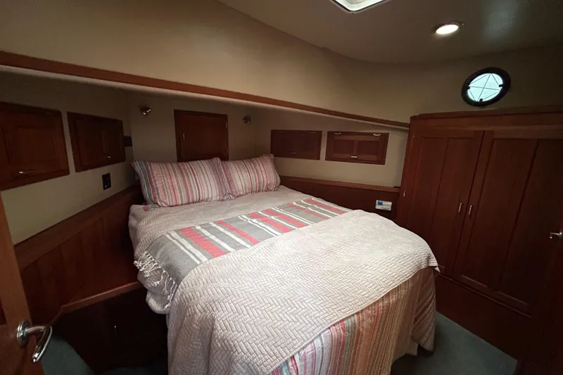 Slide: The Image of Cozy bedroom in 2003 American Tug 34 with striped bedding and wooden cabinetry. - 12