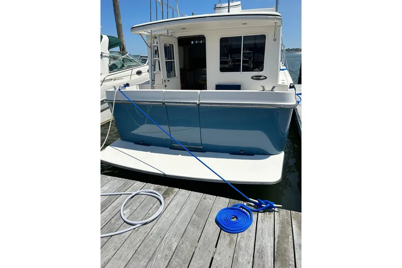 Slide: The Image of American Tug 34, 2003 model, docked with blue mooring lines. - 3
