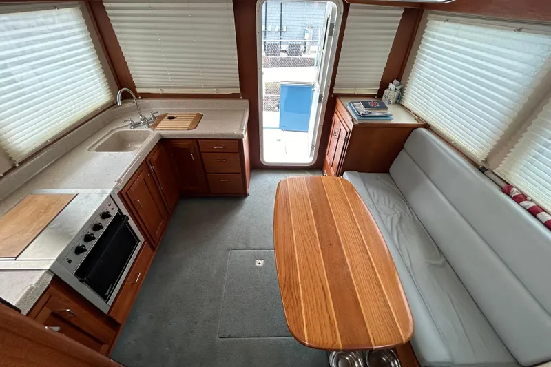 Slide: The Image of Interior of a 2003 American Tug 34, featuring a cozy kitchen and dining area. - 5