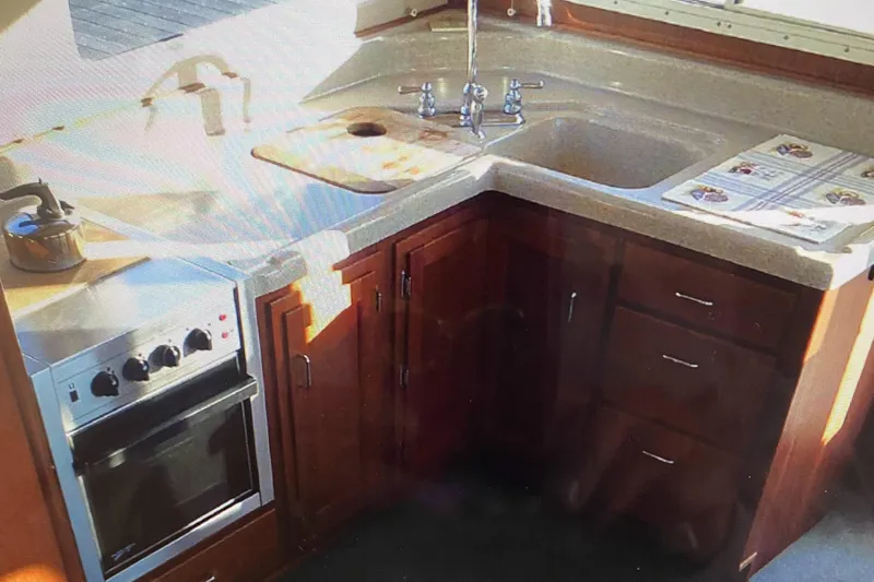 Slide: The Image of 2003 American Tug 34 kitchen with stove, sink, and wooden cabinets. - 8