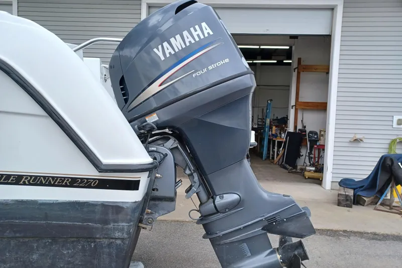 Slide: The Image of 2008 Glacier Bay 2270 Isle Runner with Yamaha four-stroke outboard motor in a garage setting. - 2
