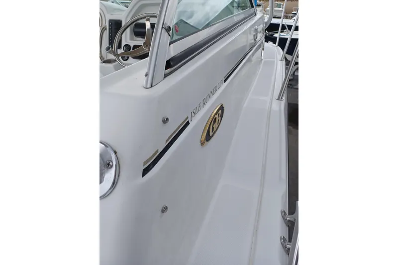 Slide: The Image of 2008 Glacier Bay 2270 Isle Runner boat side view with steering wheel visible. - 8