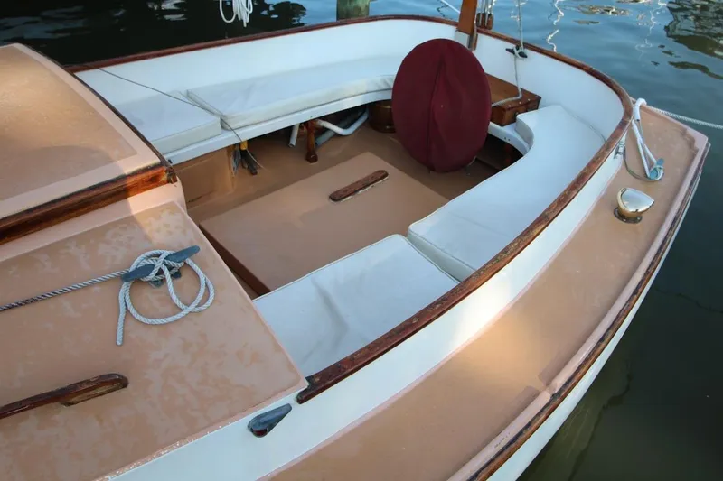 Slide: The Image of 1974 Marshall 22 Cape Cod Catboat with white seating and wooden accents on calm water. - 11