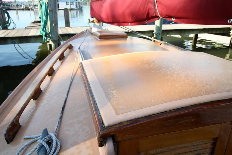 Slide: The Image of 1974 Marshall 22 Cape Cod Catboat docked, showcasing deck and red sail cover. - 12