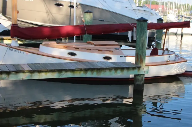 Slide: The Image of 1974 Marshall 22 Cape Cod Catboat docked at a marina with red sail cover. - 3