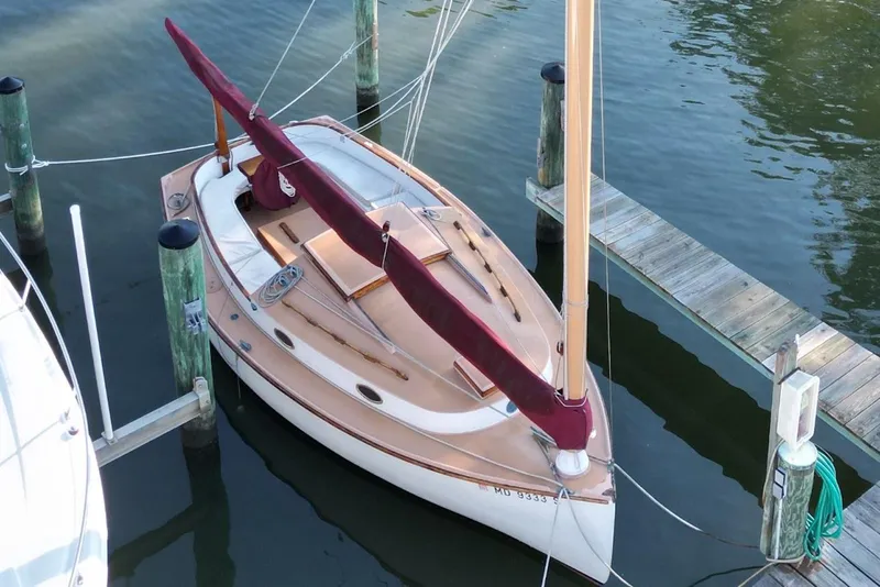 Slide: The Image of 1974 Marshall 22 Cape Cod Catboat docked in calm marina waters. - 8