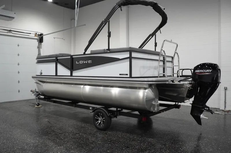 Slide: The Image of 2026 Lowe LS 190 pontoon boat with Mercury outboard motor in a showroom. - 14