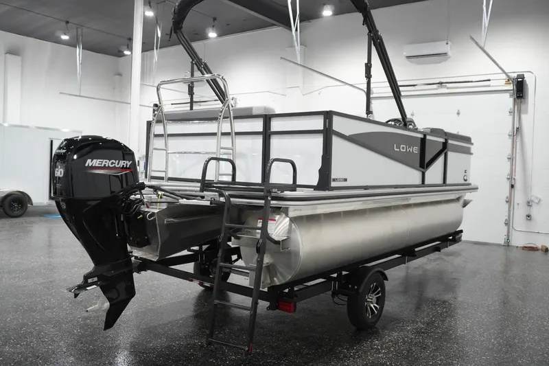 Slide: The Image of 2026 Lowe LS 190 pontoon boat with Mercury engine in showroom setting. - 16