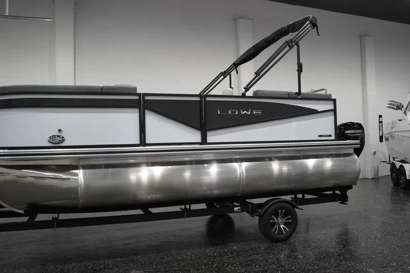 Slide: The Image of 2026 Lowe LS 190 pontoon boat in showroom, featuring sleek design and Mercury engine. - 3