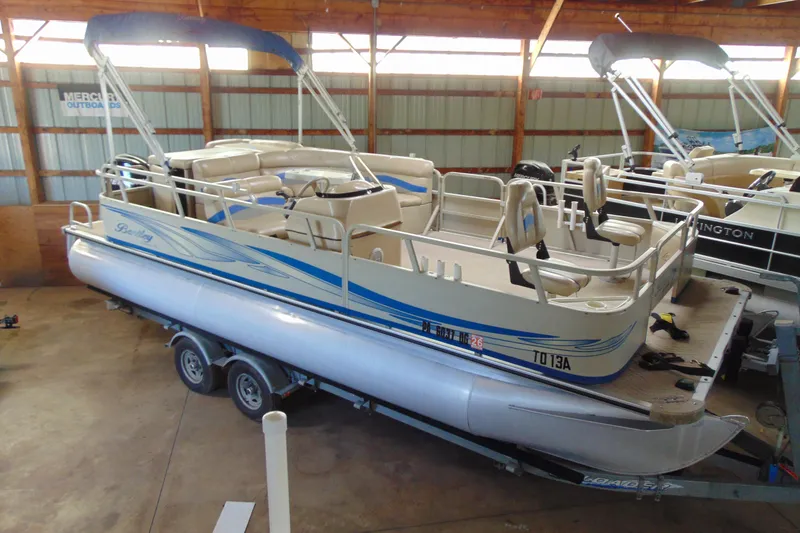 The Image of 2010 Bentley Pontoons 220 Fish boat with blue accents in a storage facility. - 1