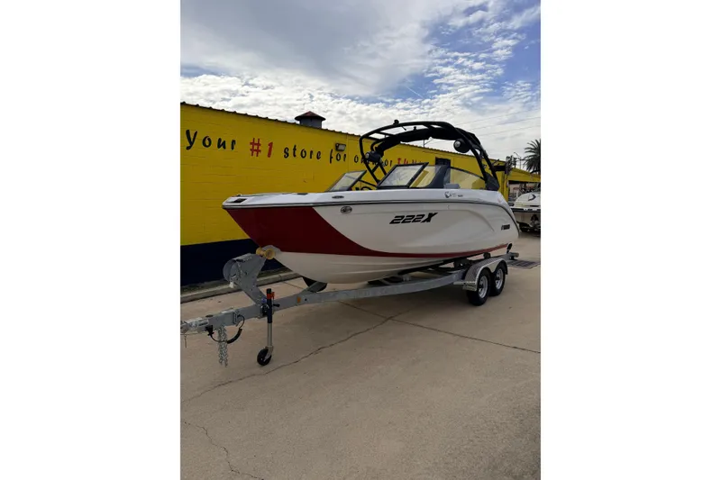 Slide: The Image of 2026 Yamaha Boats 222XD on trailer in front of yellow wall. - 2