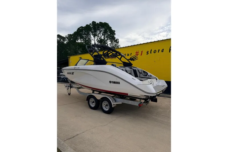 Slide: The Image of 2026 Yamaha Boats 222XD on trailer in front of yellow building. - 3