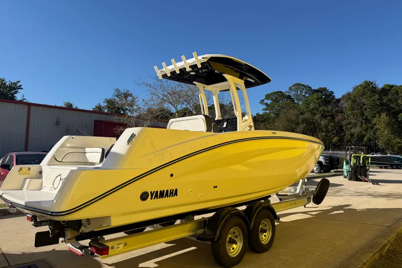 Slide: The Image of 2026 Yamaha Boats 252 FSH Sport in yellow on trailer, parked outdoors. - 10