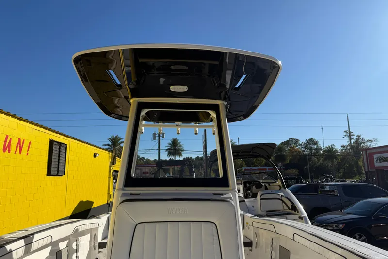 Slide: The Image of 2026 Yamaha Boats 252 FSH Sport, showcasing sleek design and spacious interior under clear blue sky. - 29