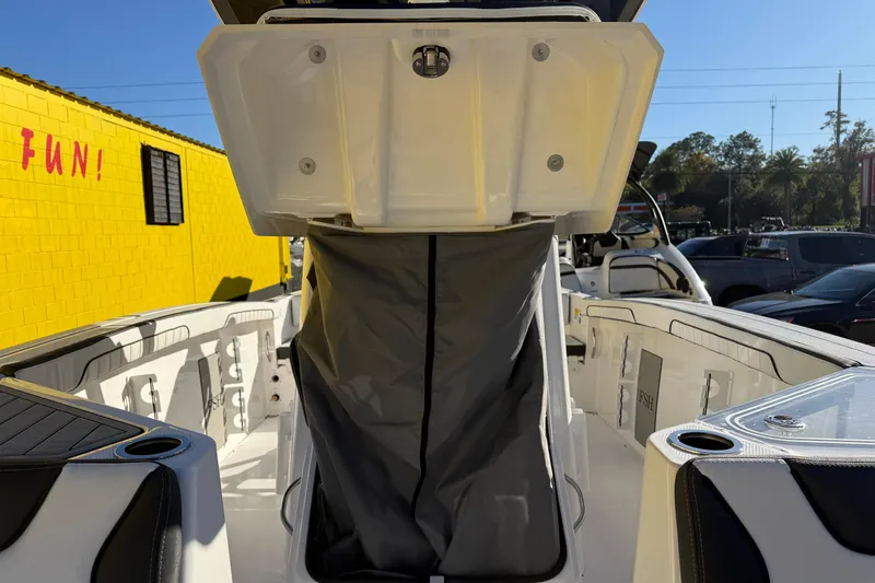 Slide: The Image of 2026 Yamaha Boats 252 FSH Sport interior with storage compartment, docked outdoors. - 30