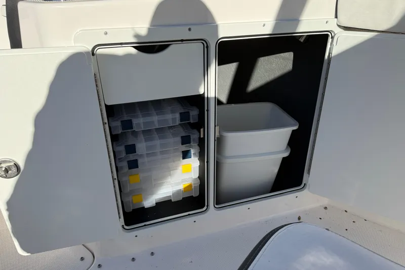 Slide: The Image of Storage compartments on a 2026 Yamaha Boats 252 FSH Sport, featuring tackle boxes and bins. - 34