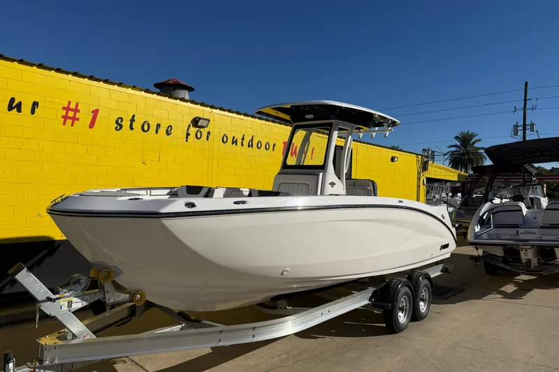 Slide: The Image of 2026 Yamaha Boats 252 FSH Sport on trailer, parked outside a yellow building. - 4