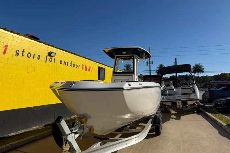 Slide: The Image of 2026 Yamaha Boats 252 FSH Sport on trailer outside a yellow building. - 5