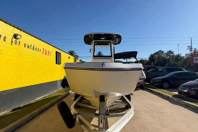 Slide: The Image of 2026 Yamaha Boats 252 FSH Sport on trailer, parked near a bright yellow building. - 6
